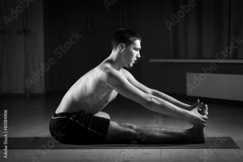 young man doing yoga in the gym