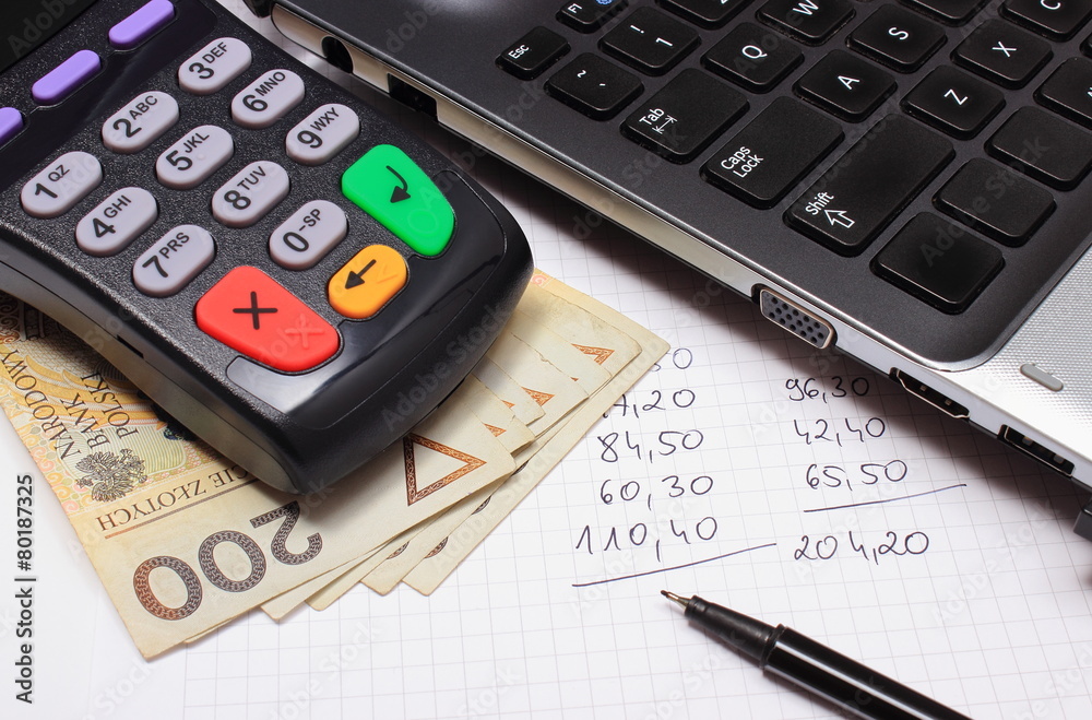 Payment terminal, money, laptop and financial calculations Payment terminal, money, laptop and financial calculations
