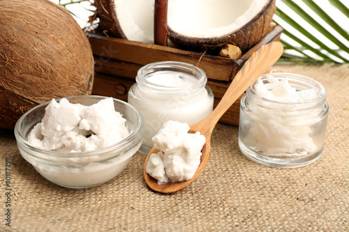 Coconut with jars of coconut oil and  cosmetic cream