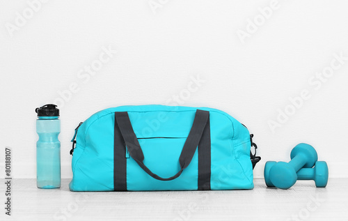 Sports bag with sports equipment in room photo