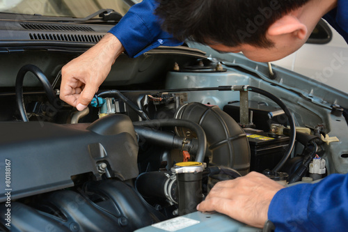 Auto mechanic checking car engine