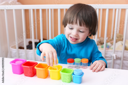 фотографія Happy little boy sorts details by color
