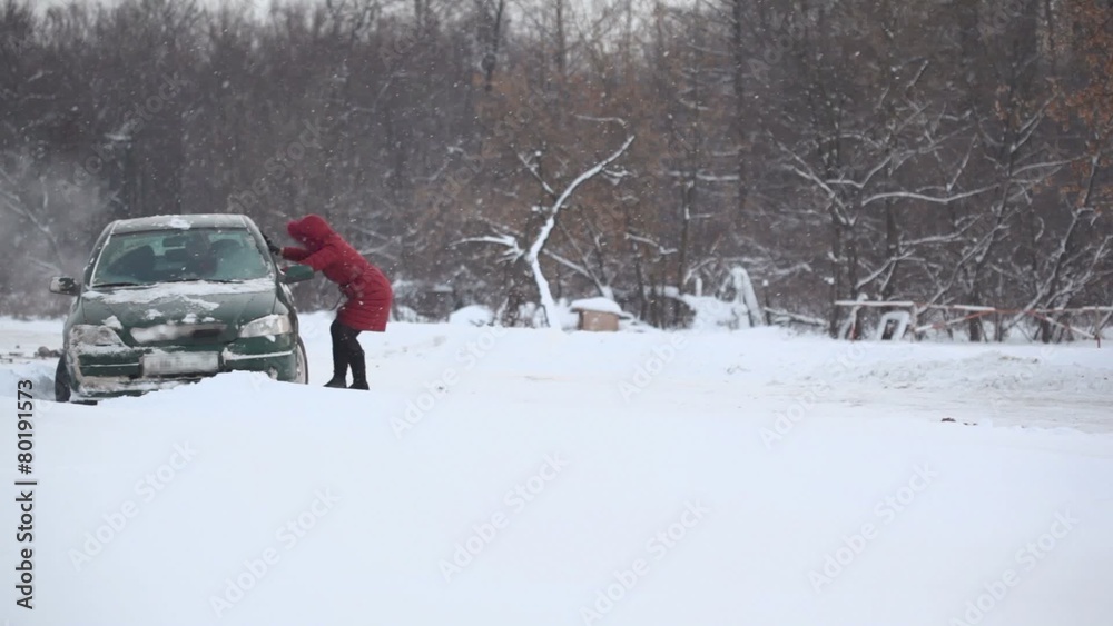 Woman helps to release car from snow trap on country road