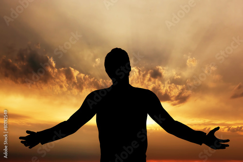 Man praying, meditating in harmony and peace at sunset