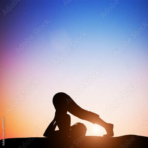 Woman in plow yoga pose meditating at sunset. Zen