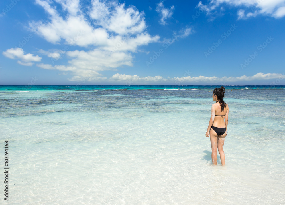 Bikini girl standing in clear tropical water