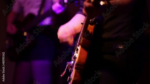 Young man and woman play on guitars on stage during concert photo