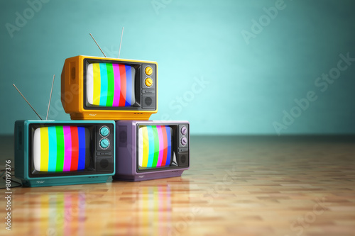 Fotografie Vintage television concept. Stack of retro tv set on green backg