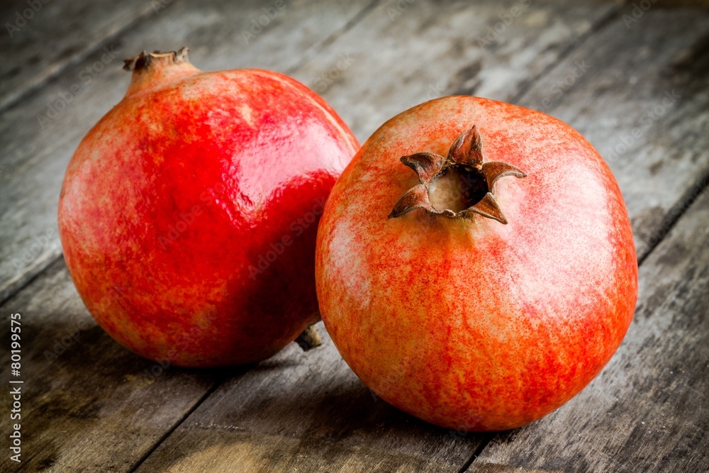 two ripe pomegranate on a wooden background two ripe pomegranate on a wooden background