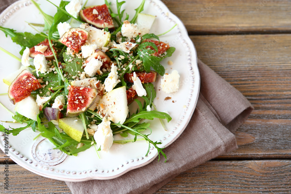 Crispy salad with arugula, sliced pears and figs on a whit Crispy salad with arugula, sliced pears and figs on a whit
