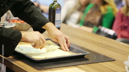 Male hands smeared piece of light dough on baking sheet photo