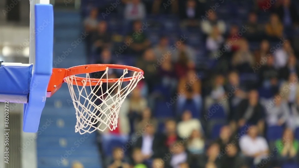 Ball fly into the basket at basketball court against spectators Ball fly into the basket at basketball court against spectators