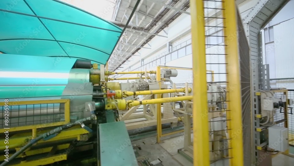 Aluminum sheet is wound in roll on special machine in workshop Aluminum sheet is wound in roll on special machine in workshop
