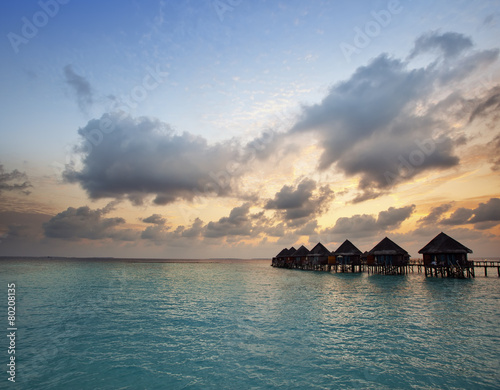Houses over the sea at sunrise. Maldives