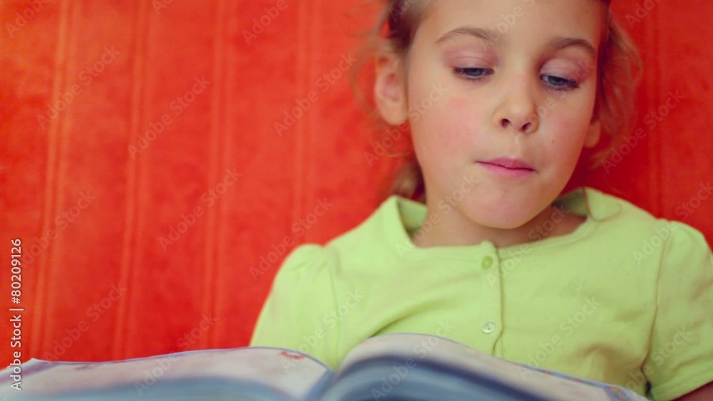 Little girl turns pages and then reads syllables from book Little girl turns pages and then reads syllables from book