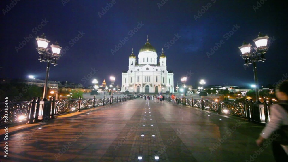 People walk by road near Christ Savior Cathedral at night in Moscow People walk by road near Christ Savior Cathedral at night in Moscow