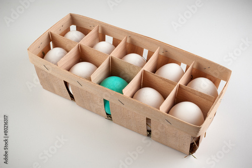 pack of ten white eggs with one blue photo