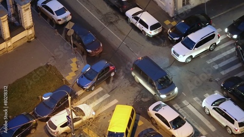 Cars jam at the crossroads of narrow streets in evening photo