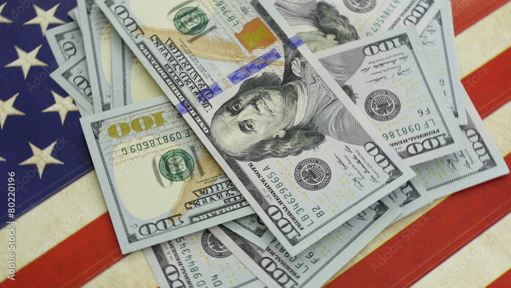 Pile of hundred dollar bills on American flag in 4K UHD Pile of hundred dollar bills on American flag in 4K UHD