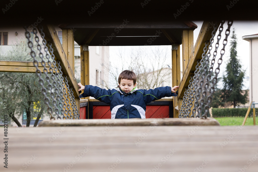 child in the playground passing over the chain bridge child in the playground passing over the chain bridge