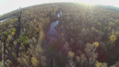 Sun shines above forest around Putyaevsky pond  photo