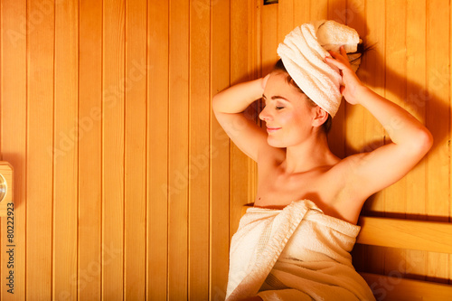 woman relaxing in wooden sauna room