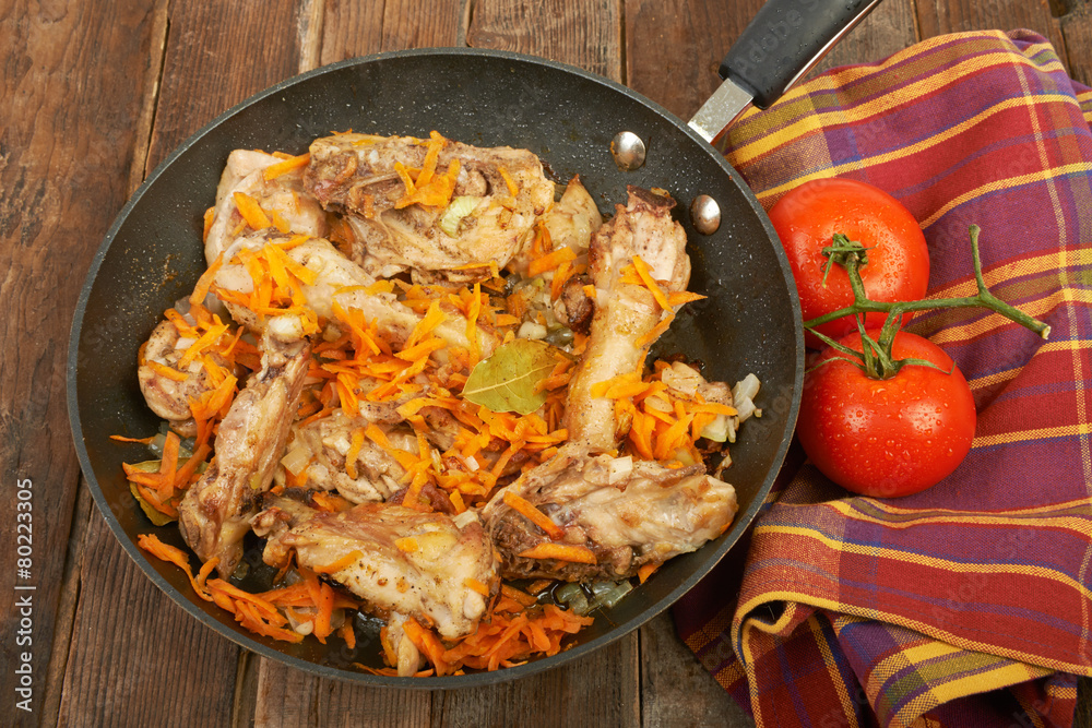 Fried chicken in the pan on a wooden background Fried chicken in the pan on a wooden background