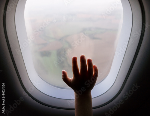 child hand on a aeroplane vindow photo