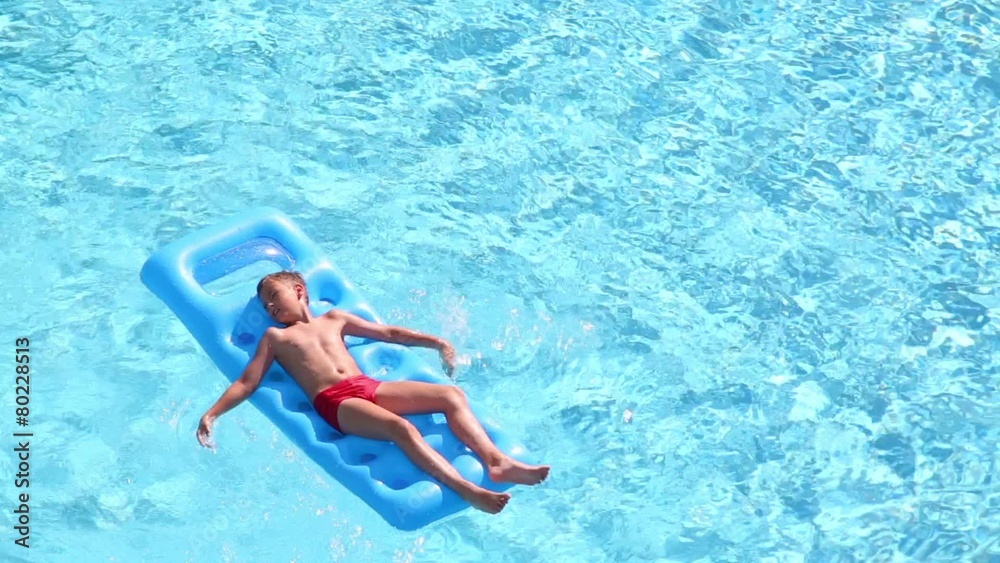 Boy floats lying on back at inflatable mattress Boy floats lying on back at inflatable mattress