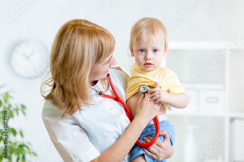 pediatrician examining hear...