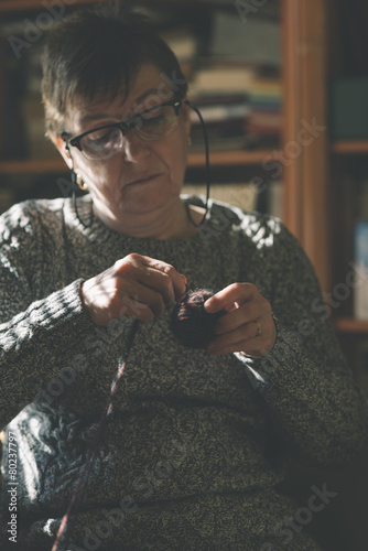 woman sitting on settee knitting