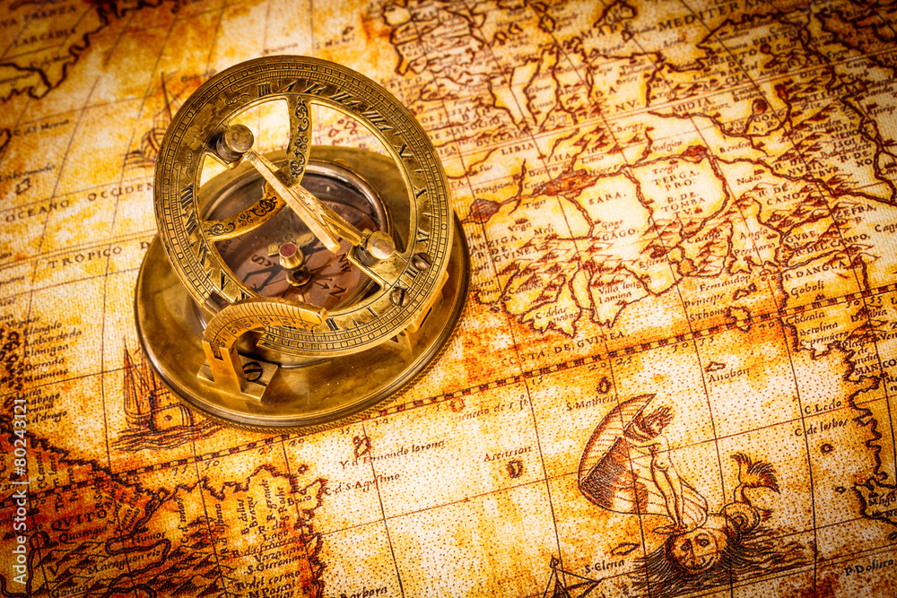 Naklejka premium Vintage compass lies on an ancient world map.