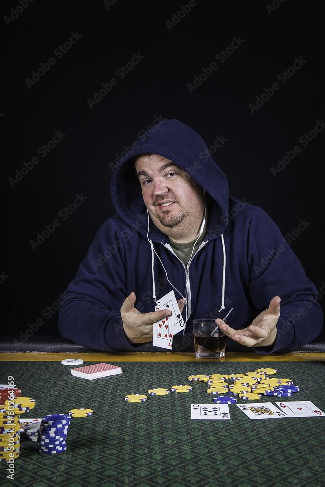 A man playing poker sitting at a table bluffing
