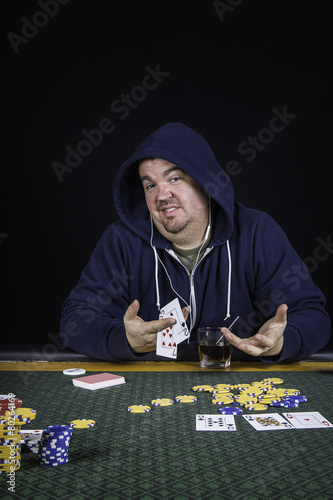 Tablou pe pânză A man playing poker sitting at a table bluffing