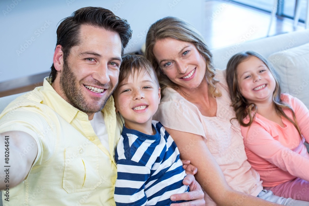 Happy family taking selfie on couch