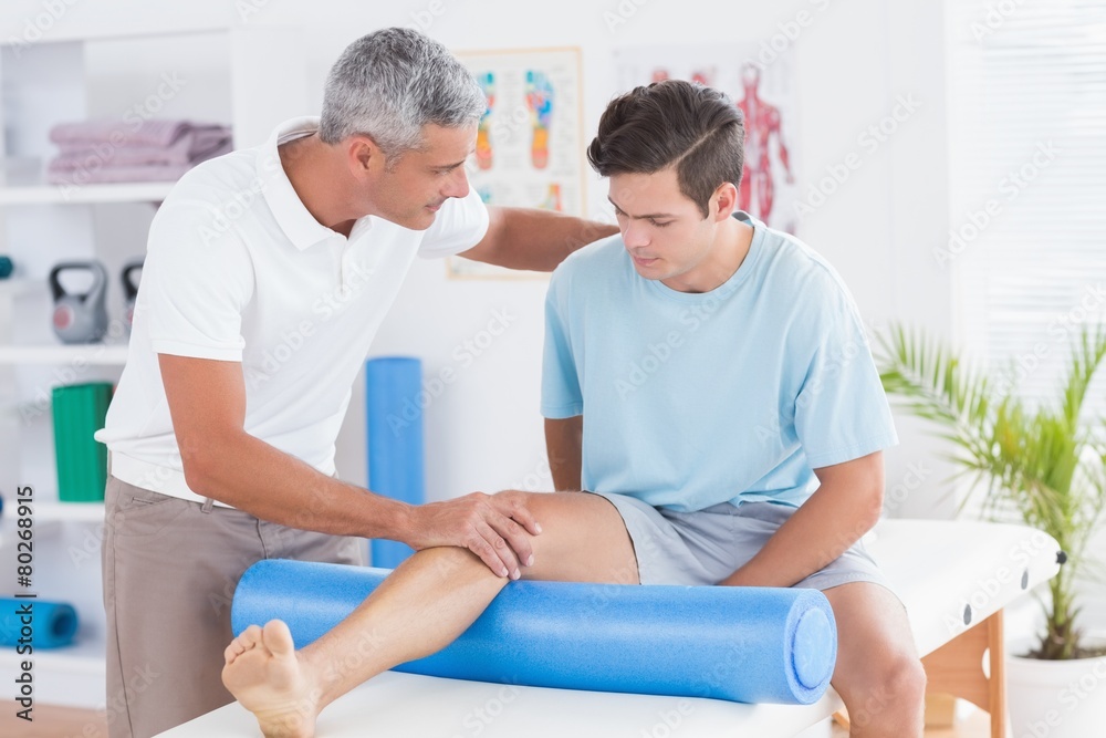 Obraz premium Doctor examining his patient leg