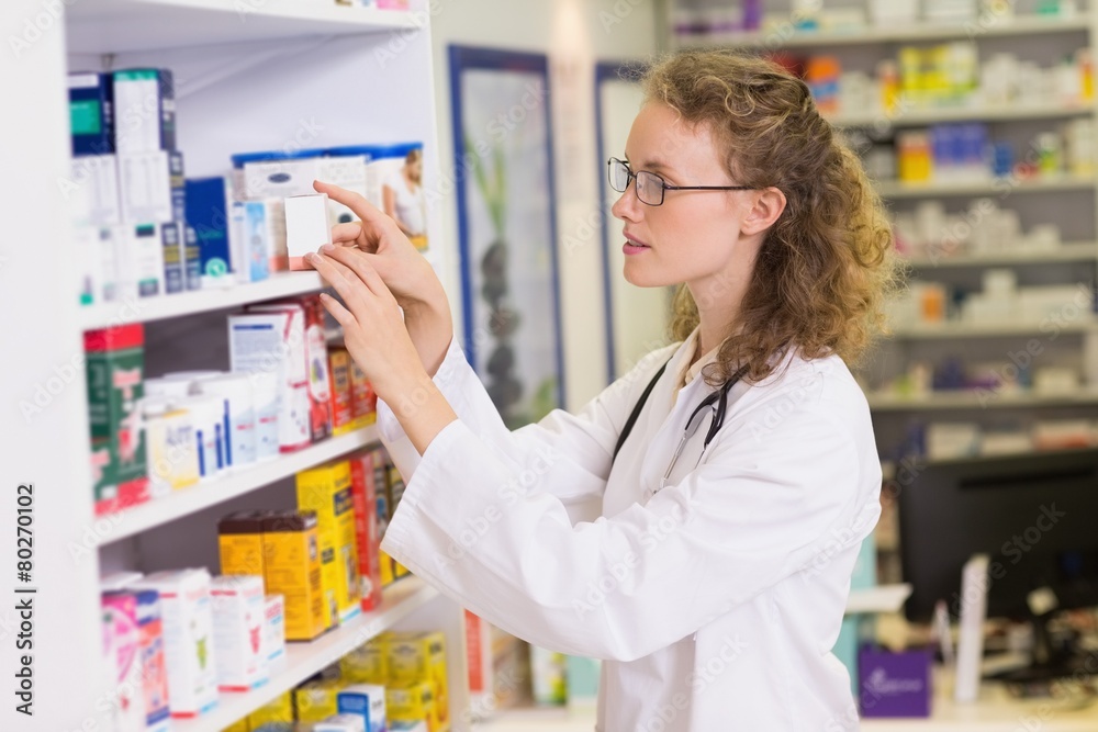 smiling pharmacist taking jar from shelf