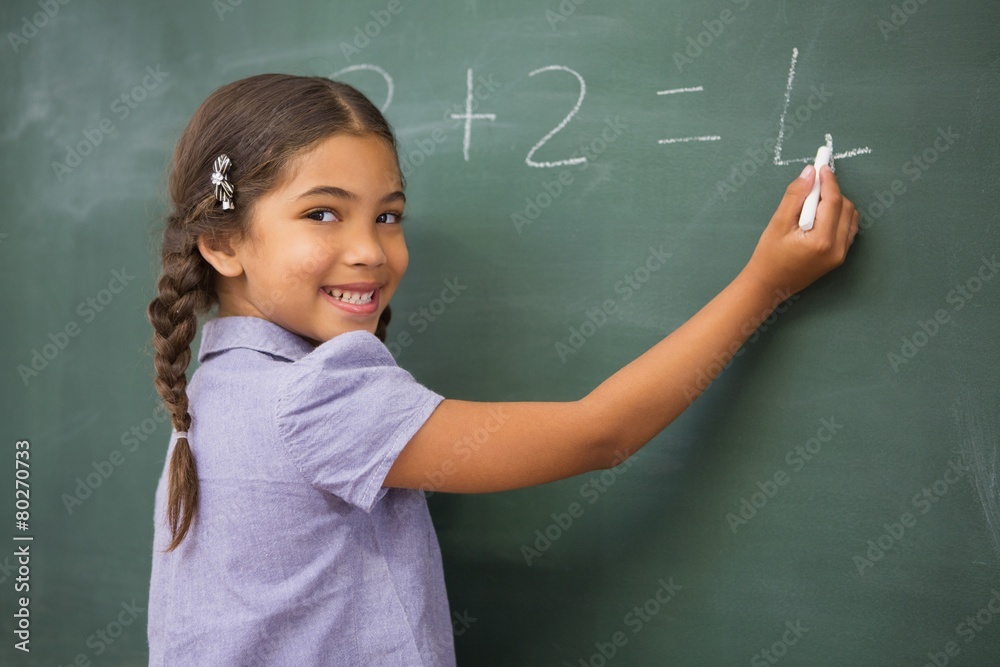 Pupil writing numbers on a blackboard