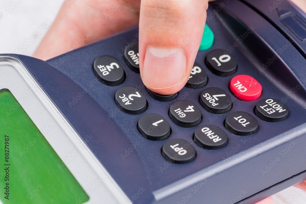 Man entering his pin on terminal Man entering his pin on terminal