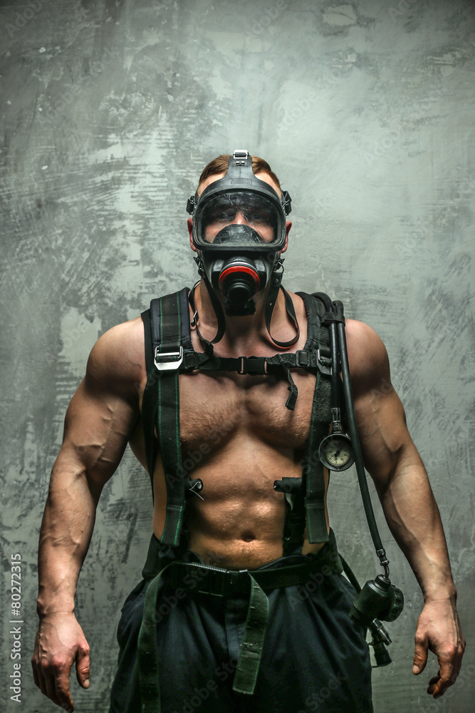 Muscular firefighter in oxygen mask