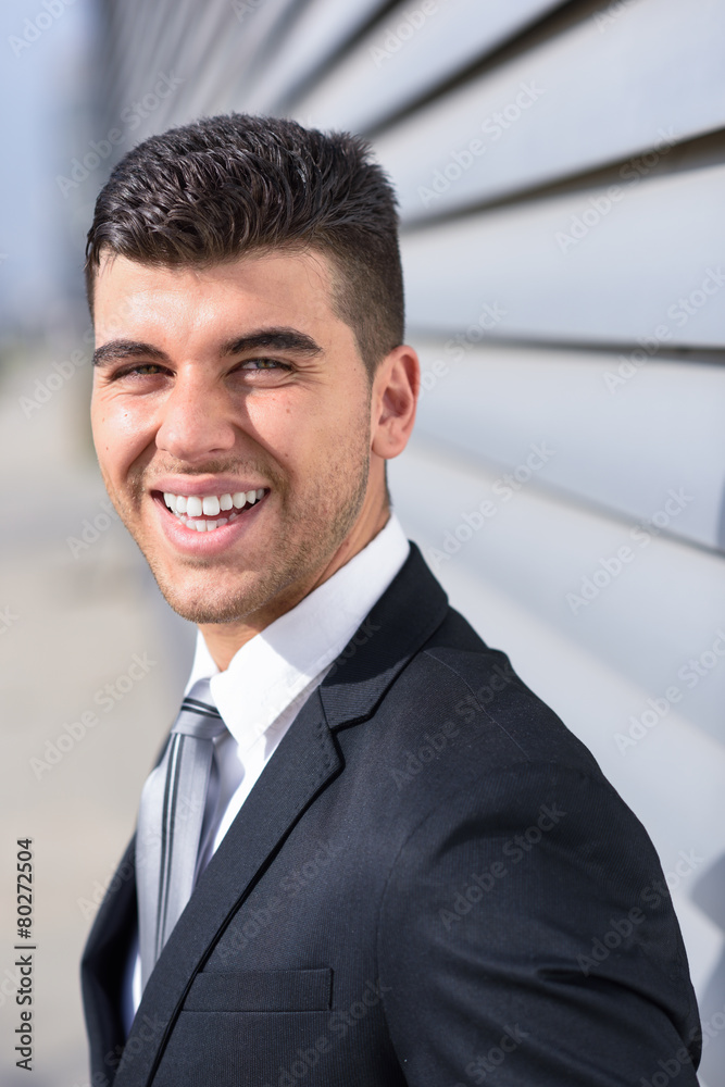 Young businessman near a office building wearing black suit Young businessman near a office building wearing black suit