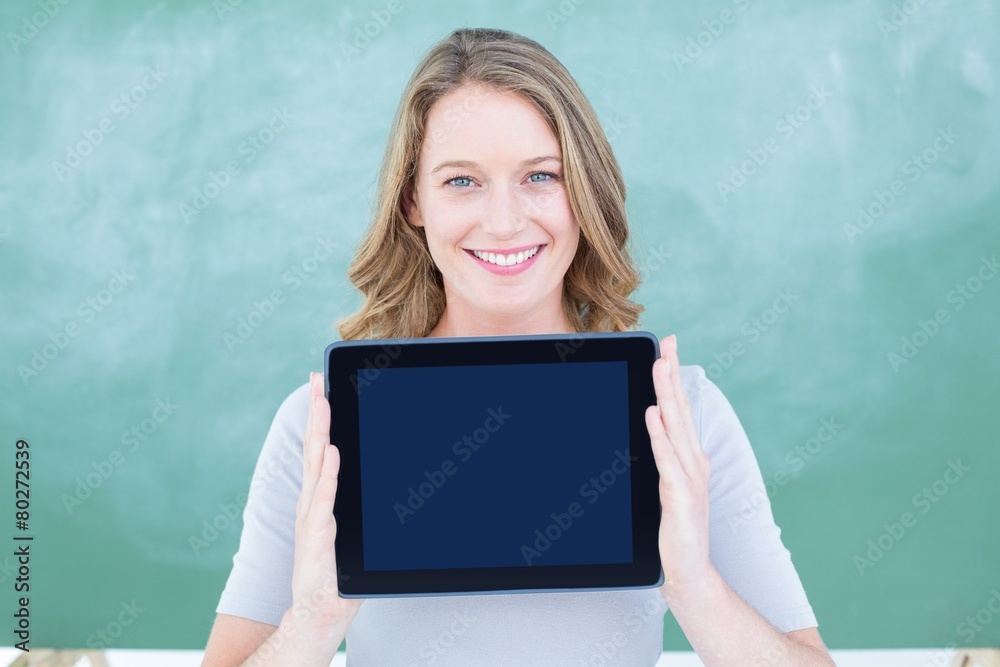 Smiling teacher holding tablet pc in front of blackboard Smiling teacher holding tablet pc in front of blackboard