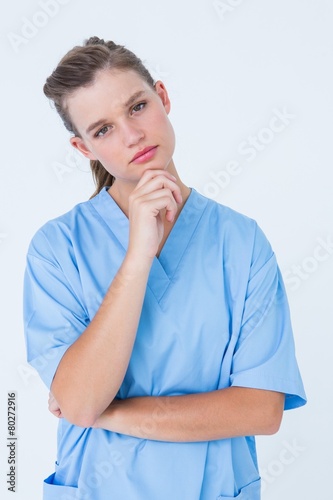Thoughtful nurse looking at camera with hand on chin