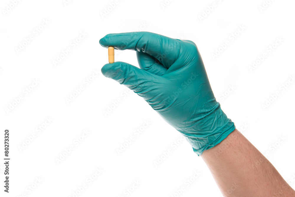 Fototapeta premium Hand with glove holds a pill up