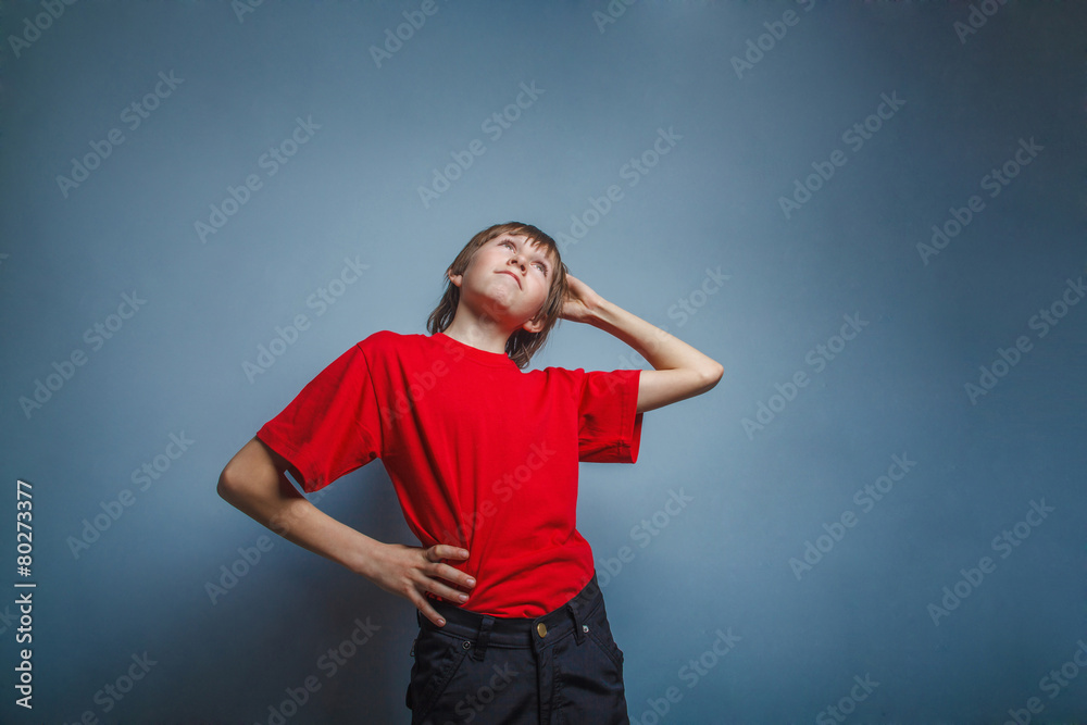 Boy, teenager, twelve years in red shirt, thoughtful, derzhet h Boy, teenager, twelve years in red shirt, thoughtful, derzhet h