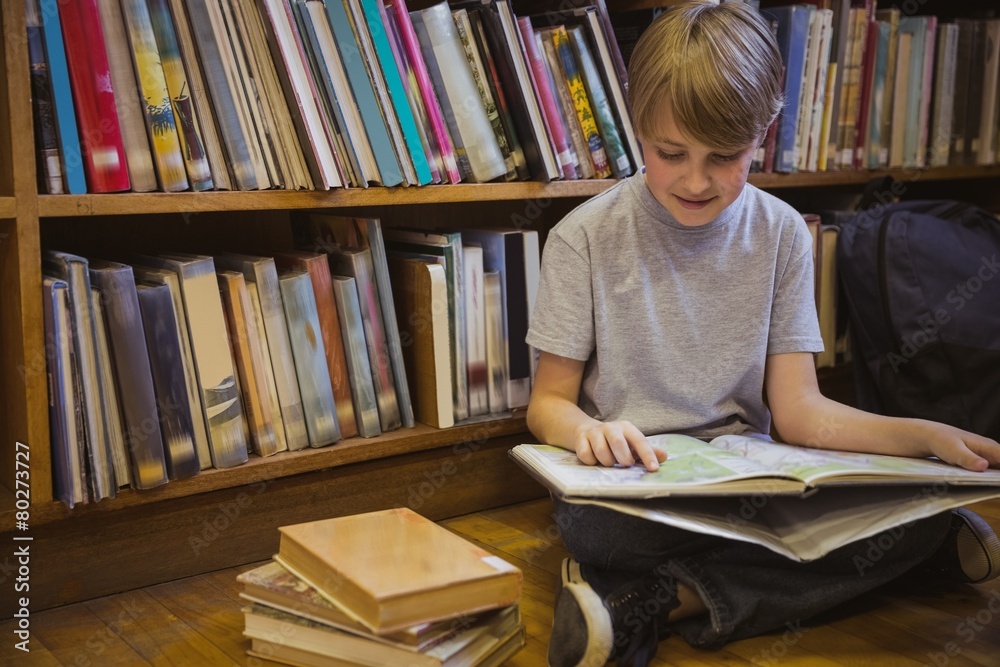 Little boy reading on library floor Little boy reading on library floor