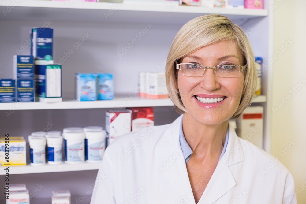 Smiling pharmacist in lab coat looking at camera