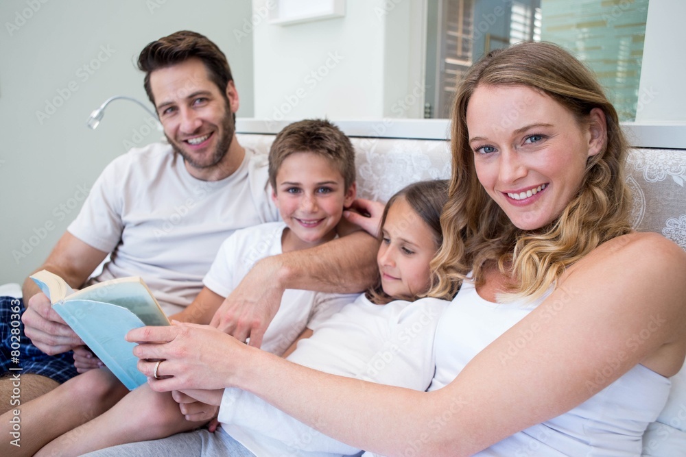 Happy family on the bed reading book