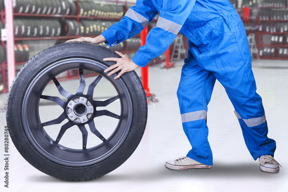 Technician changing a tire at workshop Technician changing a tire at workshop