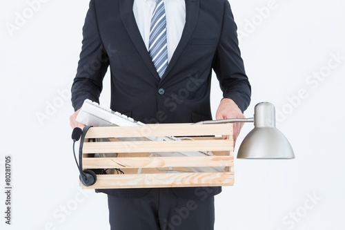 Businessman holding box of his things photo